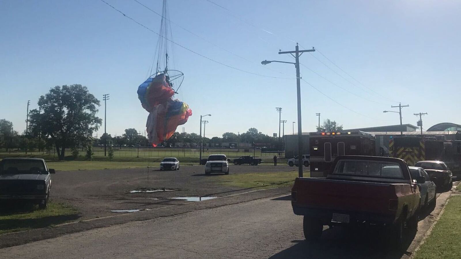 First responders checking on a paraglider stuck on a power line in Owasso on April 30. (Owasso Police Department)