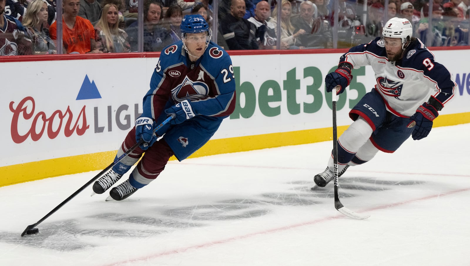 Colorado Avalanche center Nathan MacKinnon (29) moves the puck behind the Columbus Blue Jackets goal as Columbus Blue Jackets defenseman Ivan Provorov (9) defends during the first period of an NHL hockey game, Saturday, Oct. 12, 2024, at Ball Arena in Denver. (Christian Murdock/The Gazette via AP)