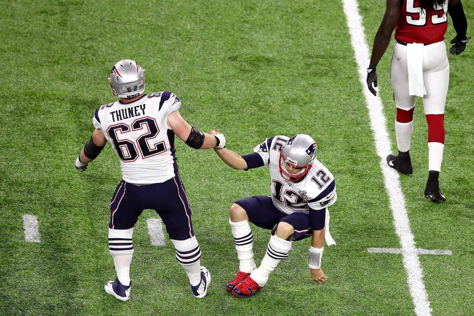 HOUSTON, TX - FEBRUARY 05: Joe Thuney #62 of the New England Patriots helps up Tom Brady #12 during the second quarter of Super Bowl 51 against the Atlanta Falcons at NRG Stadium on February 5, 2017 in Houston, Texas. (Photo by Ezra Shaw/Getty Images)