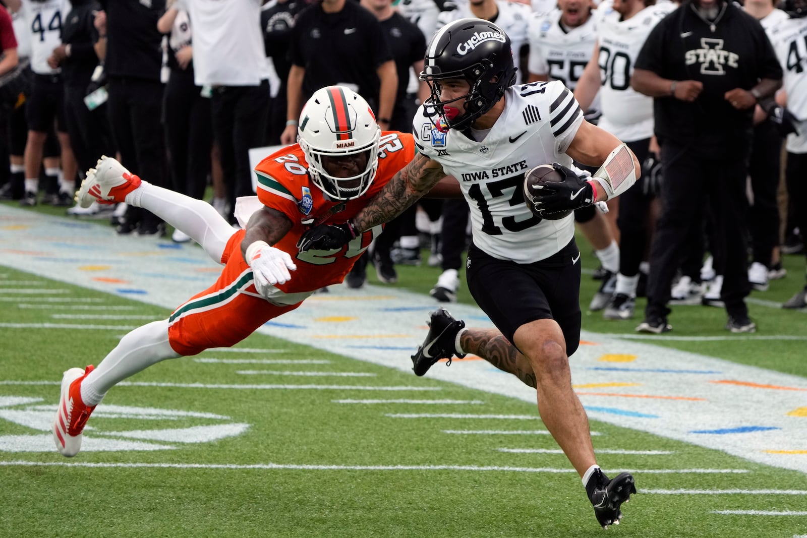 Iowa State wide receiver Jaylin Noel (13) runs after a reception before he is tackled by Miami defensive back Zaquan Patterson (20) during the first half of the Pop Tarts Bowl NCAA college football game, Saturday, Dec. 28, 2024, in Orlando, Fla. (AP Photo/John Raoux)