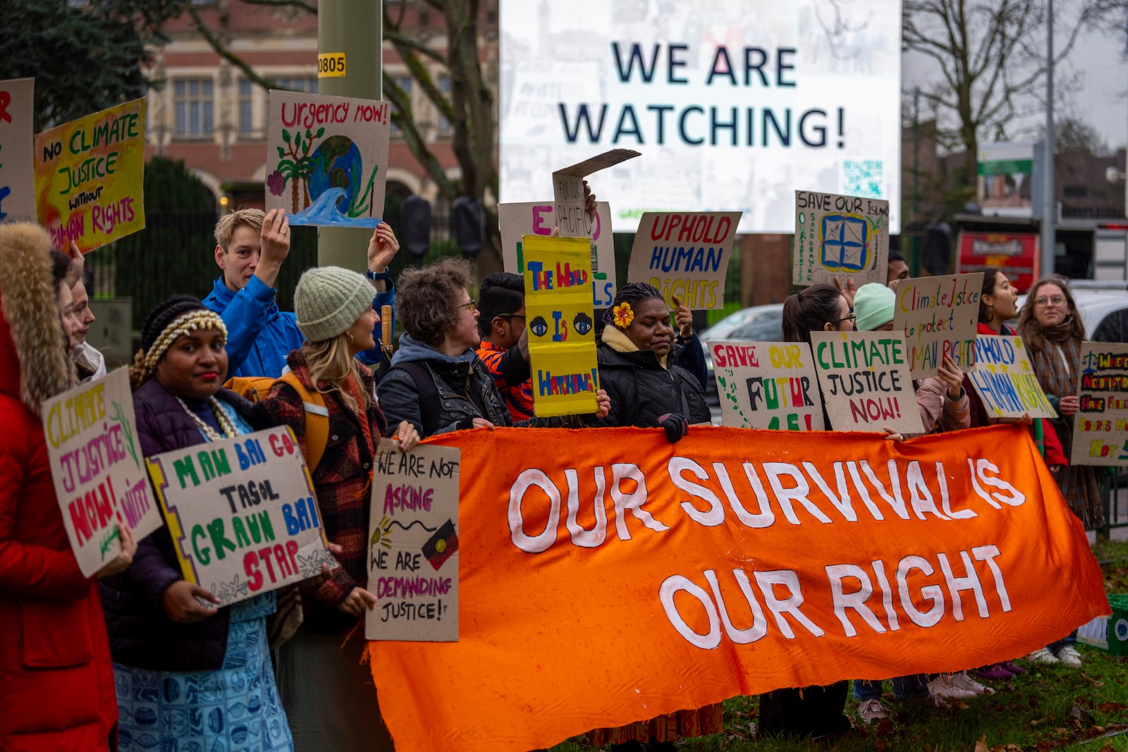 Activists protest outside the International Court of Justice, in The Hague, Netherlands, as it opens hearings into what countries worldwide are legally required to do to combat climate change and help vulnerable nations fight its devastating impact, Monday, Dec. 2, 2024. (AP Photo/Peter Dejong)