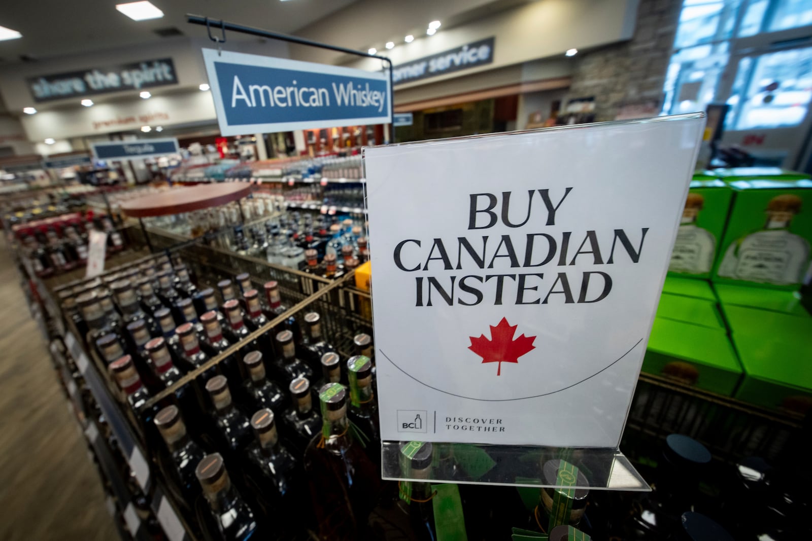 A sign is placed in front of the American whiskey section at a B.C. liquor store after top selling American made products have been removed from shelves in Vancouver, B.C., Sunday, Feb. 2, 2025. (Ethan Cairns/The Canadian Press via AP)