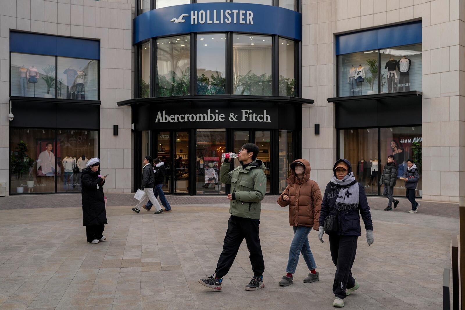 Chinese shoppers tour past American fashion boutiques at an outdoor shopping mall in Beijing, Tuesday, Feb. 4, 2025. (AP Photo/Andy Wong)