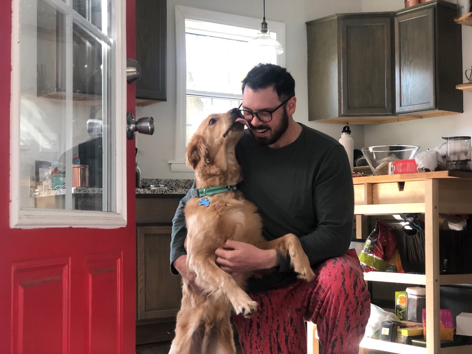 Matt Wilcox at home with his dog in the South Park neighborhood. Wilcox says he bought a home because it was cheaper than renting downtown. CORNELIUS FROLIK / STAFF