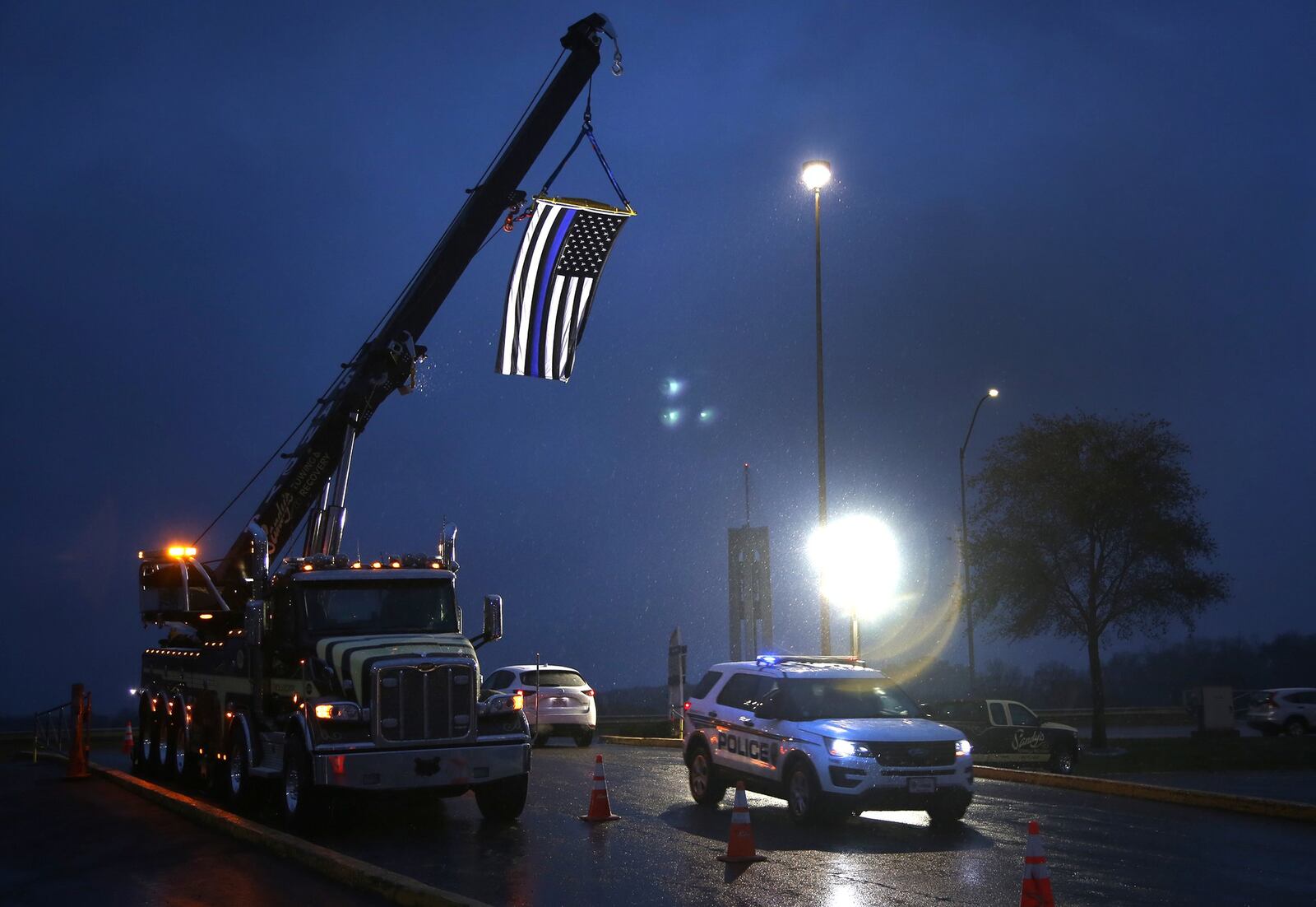 A blue and black American flag hangs over the entrance to the University of Dayton Arena during the public viewing for Dayton police Det. Jorge Del Rio Monday night. Del Rio was shot Nov. 4 while serving a search warrant on a suspected drug house. Del Rio will be honored with a procession today that will carry him through Dayton and the surrounding communities to a private service at Tobias Funeral Home. LISA POWELL / STAFF