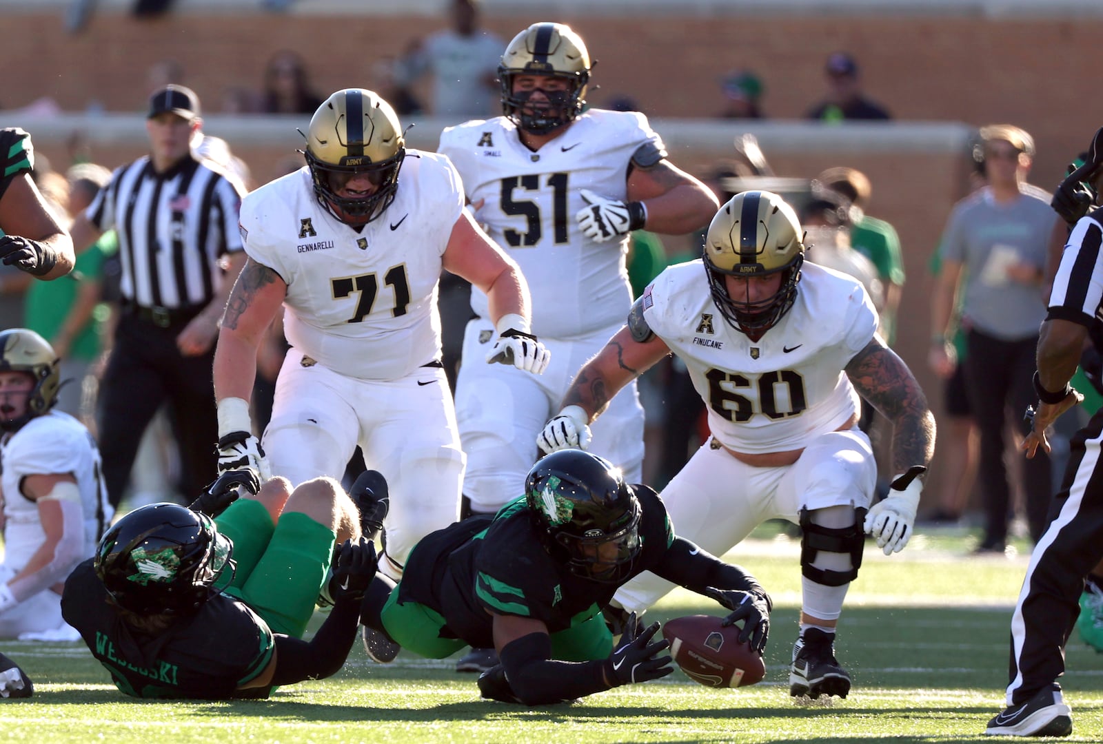 North Texas linebacker Jordan Brown (8) recovers a fumble by Army quarterback Bryson Daily ahead of Army offensive lineman Paolo Gennarelli (71), offensive lineman Brady Small (51), and offensive lineman Connor Finucane (60)in the first half of an NCAA football game Saturday, Nov. 9, 2024, in Denton, TX. (AP Photo/Richard W. Rodriguez)