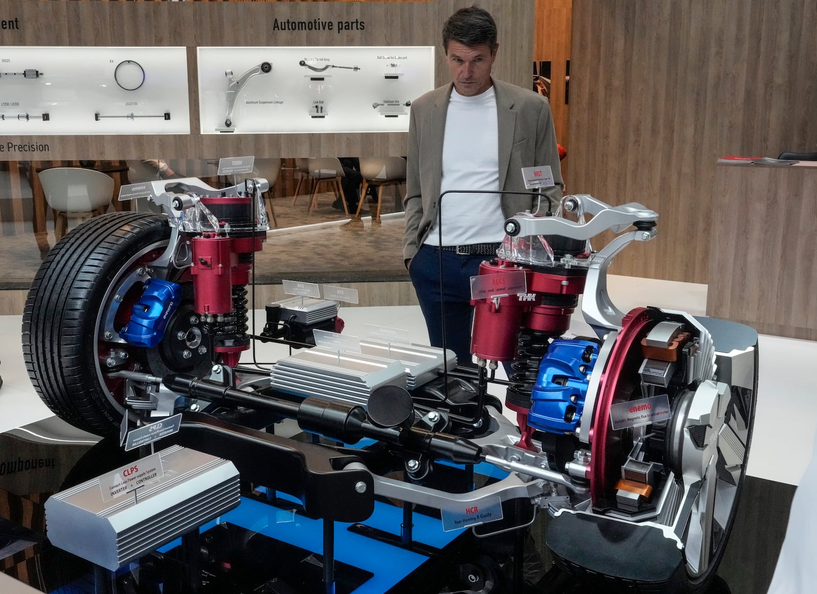 A man looks at the engine of a THK LSR-05 electric prototype at the Paris Auto Show, in Paris, Monday, Oct. 14, 2024. (AP Photo/Michel Euler)