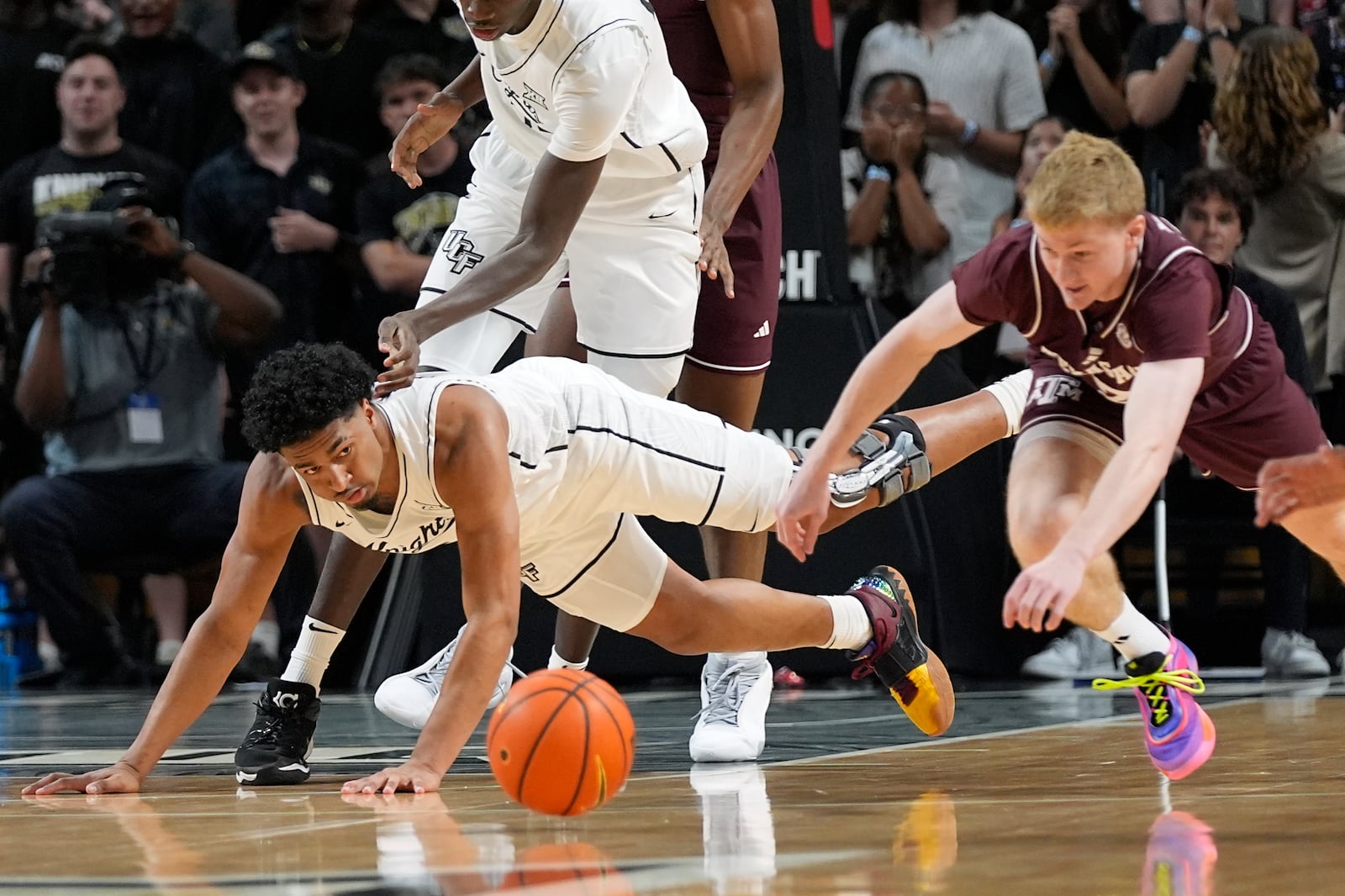 Central Florida guard Dallan Coleman, left, dives for the ball in front of Texas A&M guard Hayden Hefner, right, during the first half of an NCAA college basketball game, Monday, Nov. 4, 2024, in Orlando, Fla. (AP Photo/John Raoux)