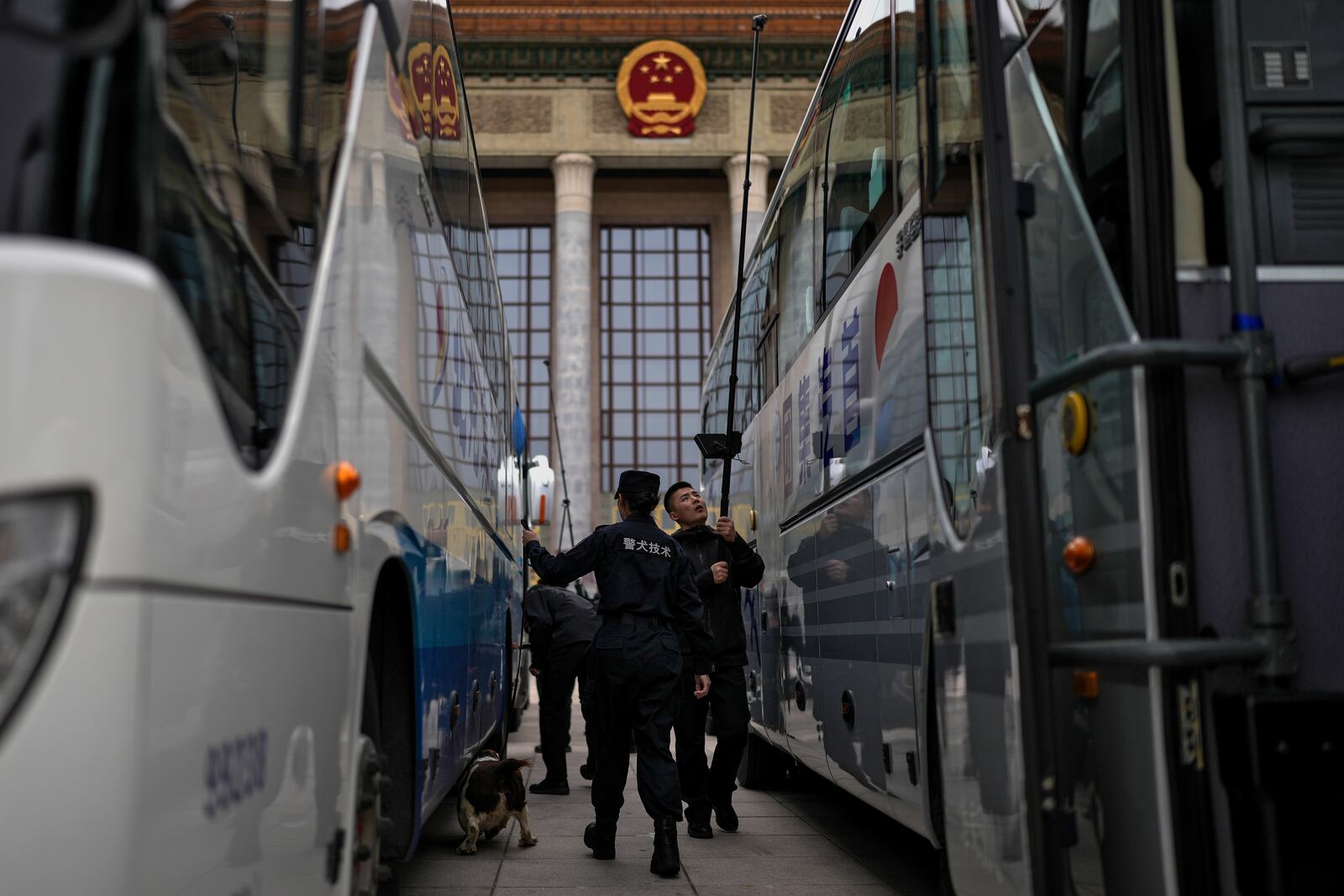 Chinese Police and Special Force's bomb squad members use sniff dog and device to check on buses parked at the Great Hall of the People during a press conference ahead of the opening of the Chinese People's Political Consultative Conference in Beijing, Monday, March 3, 2025. (AP Photo/Andy Wong)