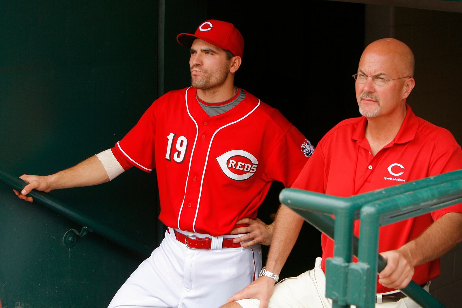 Reds Medical Director Tim Kremchek, right, stands with Joey Votto in the Cincinnati Reds dugout. Photo courtesy of Beacon Orthopaedics & Sports Medicine