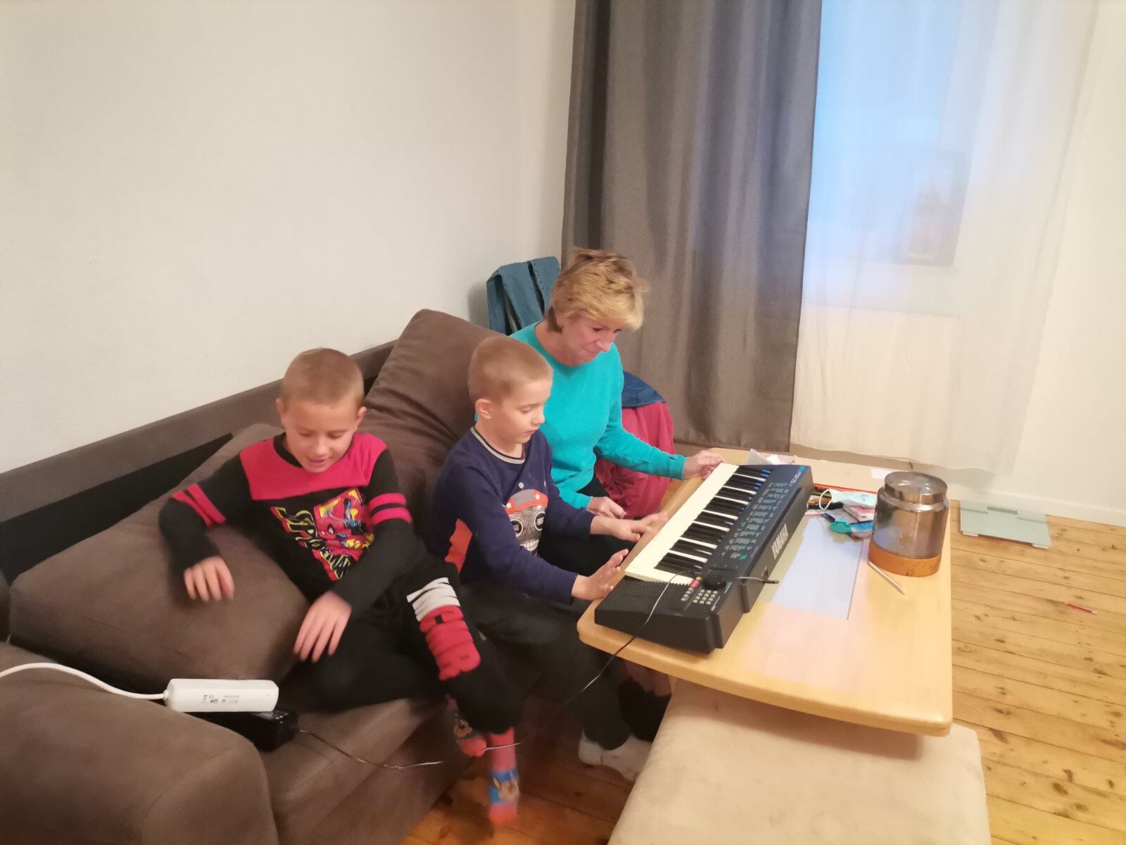 Tatiana Liaugminas' relative, Lena, and her twin boys with a keyboard donated by volunteers. (CONTRIBUTED)