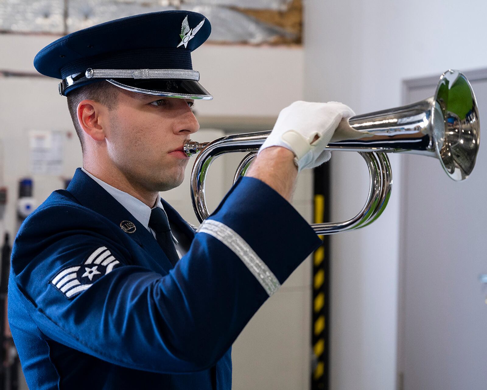 Staff Sgt. George Merusi, a new member of the Wright-Patterson Air Force Base Honor Guard, demonstrates the playing of taps as part of a military funeral during the honor guard’s graduation ceremony on April 25. The bugle holds a hidden speaker that plays the music so that Airmen on six-month temporary duty do not need to learn how to play a musical instrument. U.S. AIR FORCE PHOTO/R.J. ORIEZ