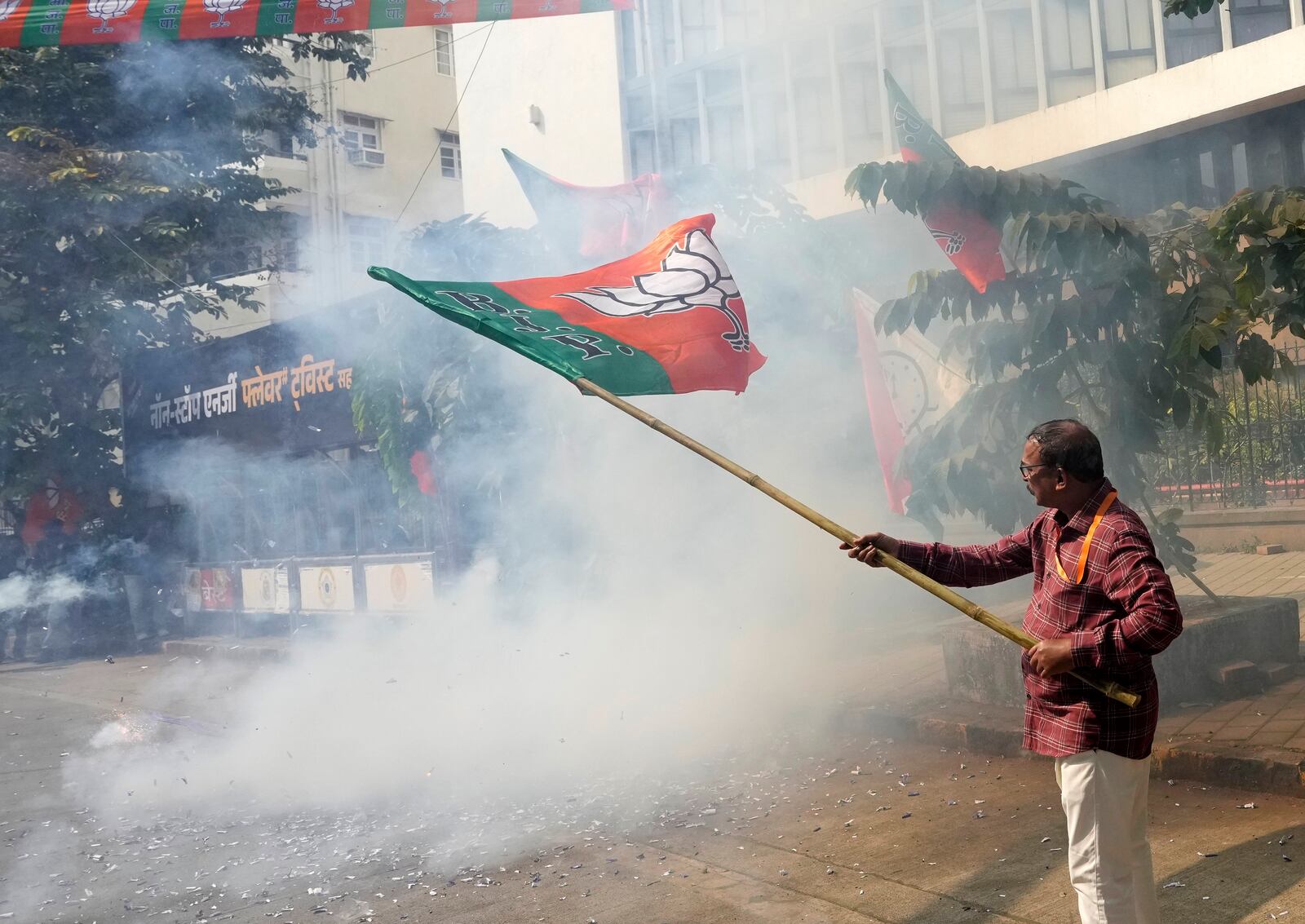 Bhartiya Janata Party worker celebrates after leading in Maharashtra state assembly elections outside party office in Mumbai, India, Saturday, Nov 23, 2024. (AP Photo/Rajanish Kakade)