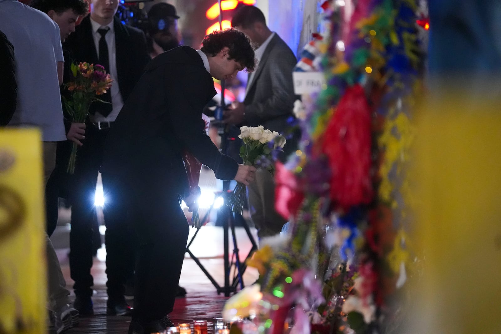 Friends of Kareem Badawi, a victim of the deadly truck attack on New Year's Day in New Orleans, place flowers at a memorial for victims after attending his funeral, Friday, Jan. 3, 2025. (AP Photo/Gerald Herbert)