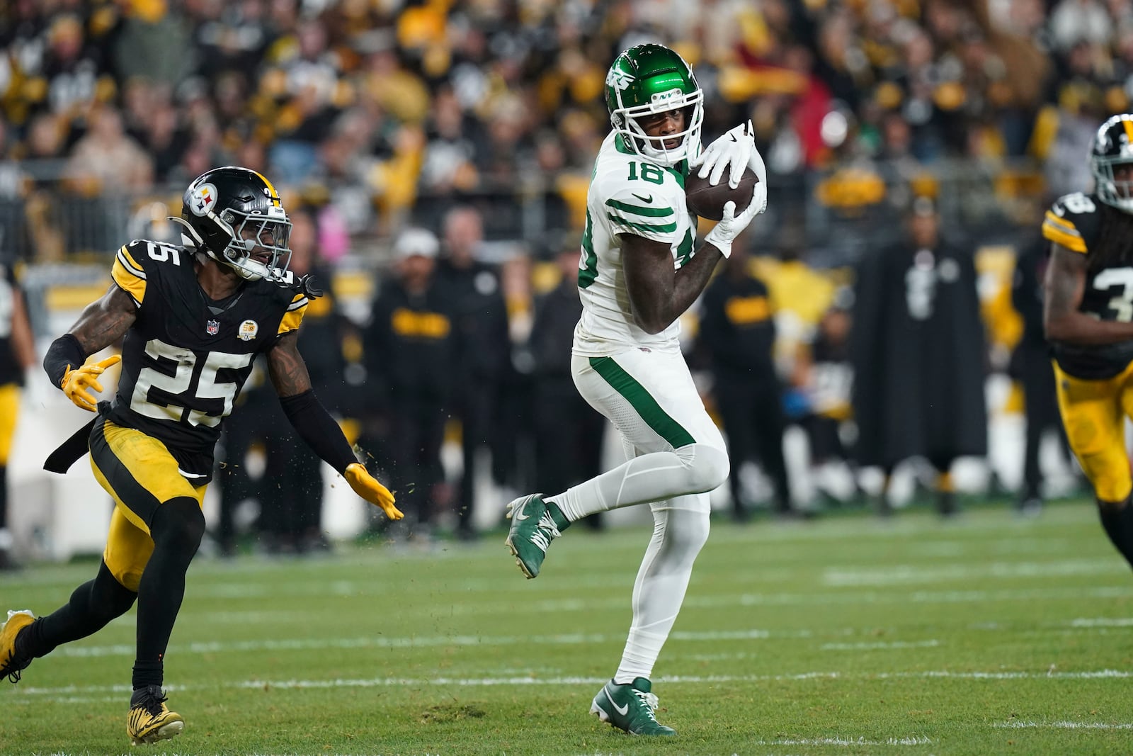 New York Jets wide receiver Mike Williams (18) pulls in a pass against Pittsburgh Steelers safety DeShon Elliott (25) in the second half of an NFL football game in Pittsburgh, Sunday, Oct. 20, 2024. (AP Photo/Matt Freed)