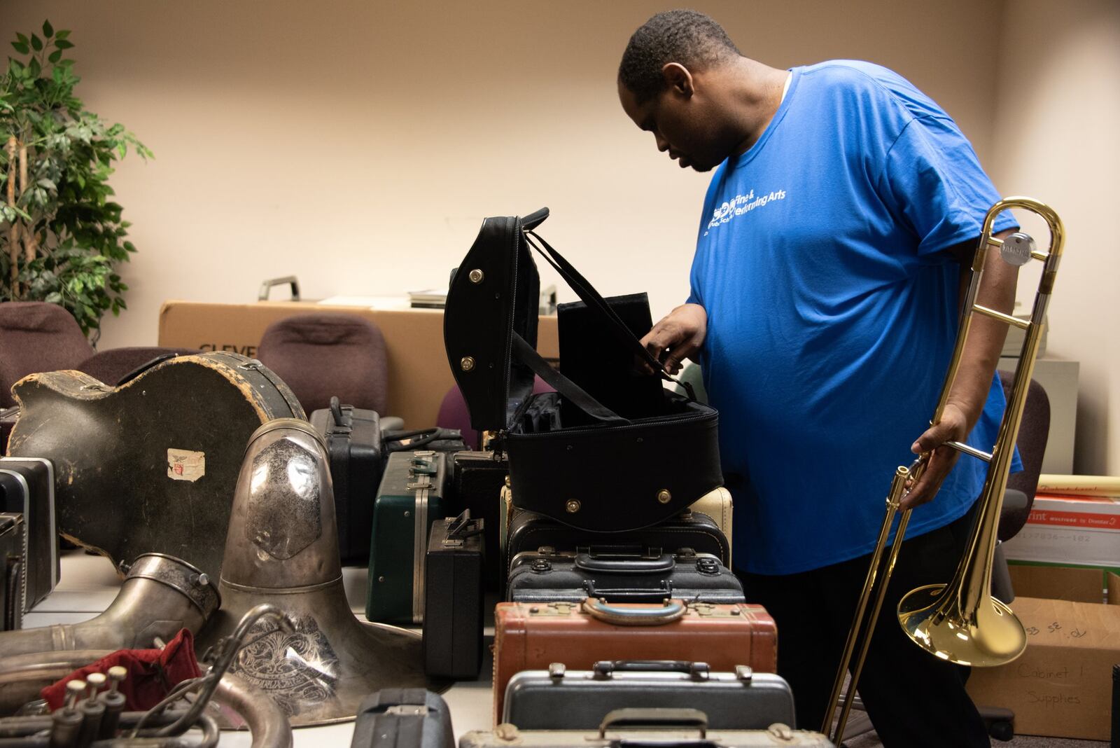 Justen Seay, coordinator of Dayton Public Schools fine arts, inspects instruments donated to DPS this summer.