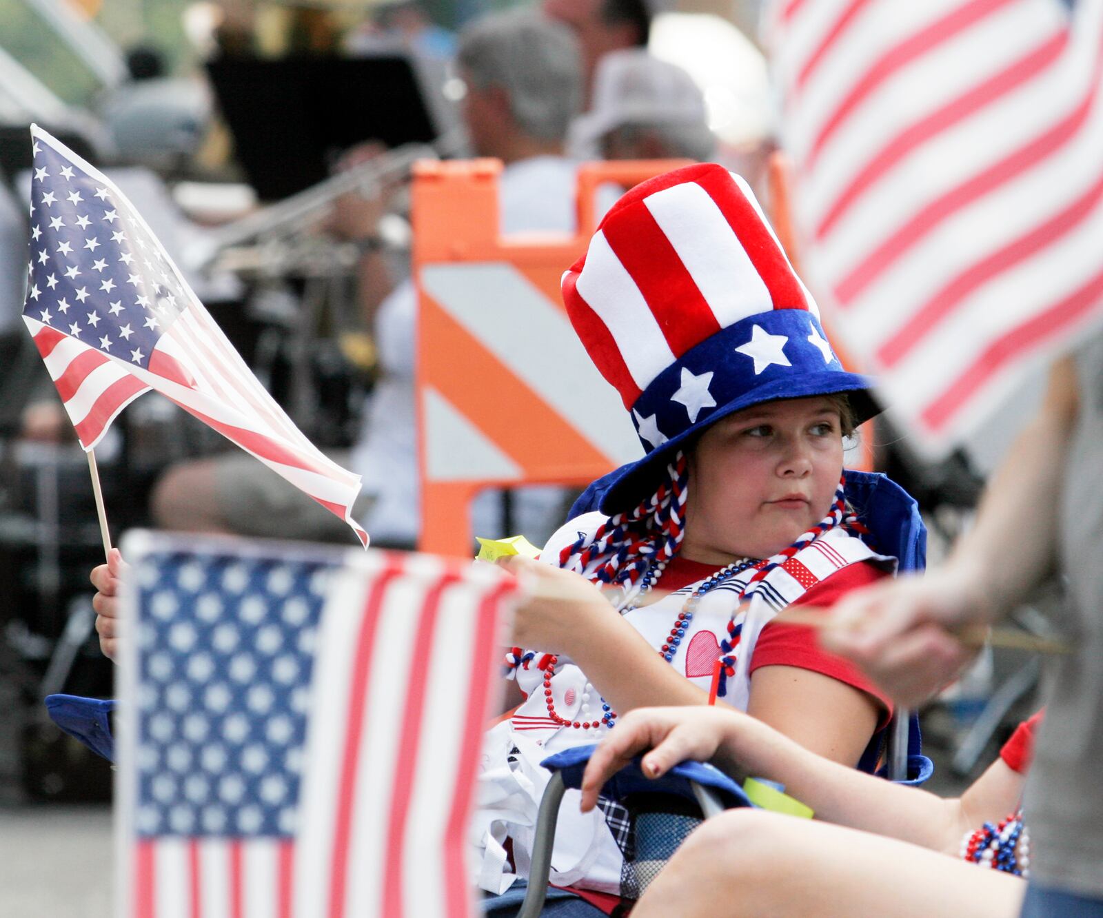 Parade watchers wave flags and dress in patriotic attire during the annual Fairborn Fourth of July parade. STAFF FILE PHOTO