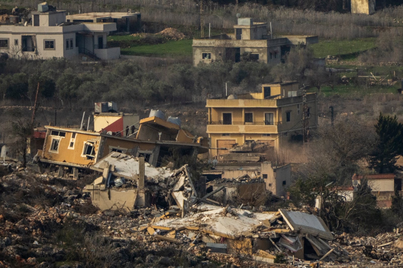 An Israeli tank maneuvers inside a village in southern Lebanon, as seen from northern Israel, Thursday, Jan. 23, 2025. (AP Photo/Ariel Schalit)