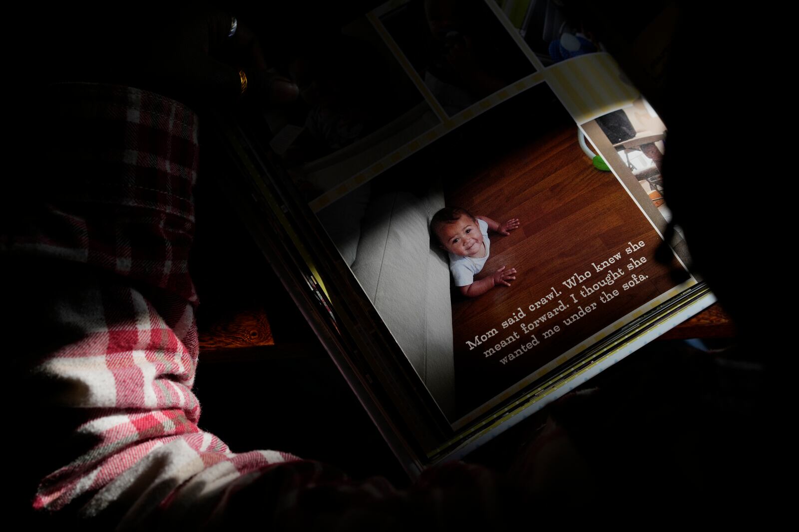 Gianna Young, 7, looks at her big bother Lucas' one-year baby book during a homeschool break in the dining room of their Sunbury, Ohio, home on Tuesday, Nov. 12, 2024. (AP Photo/Carolyn Kaster)