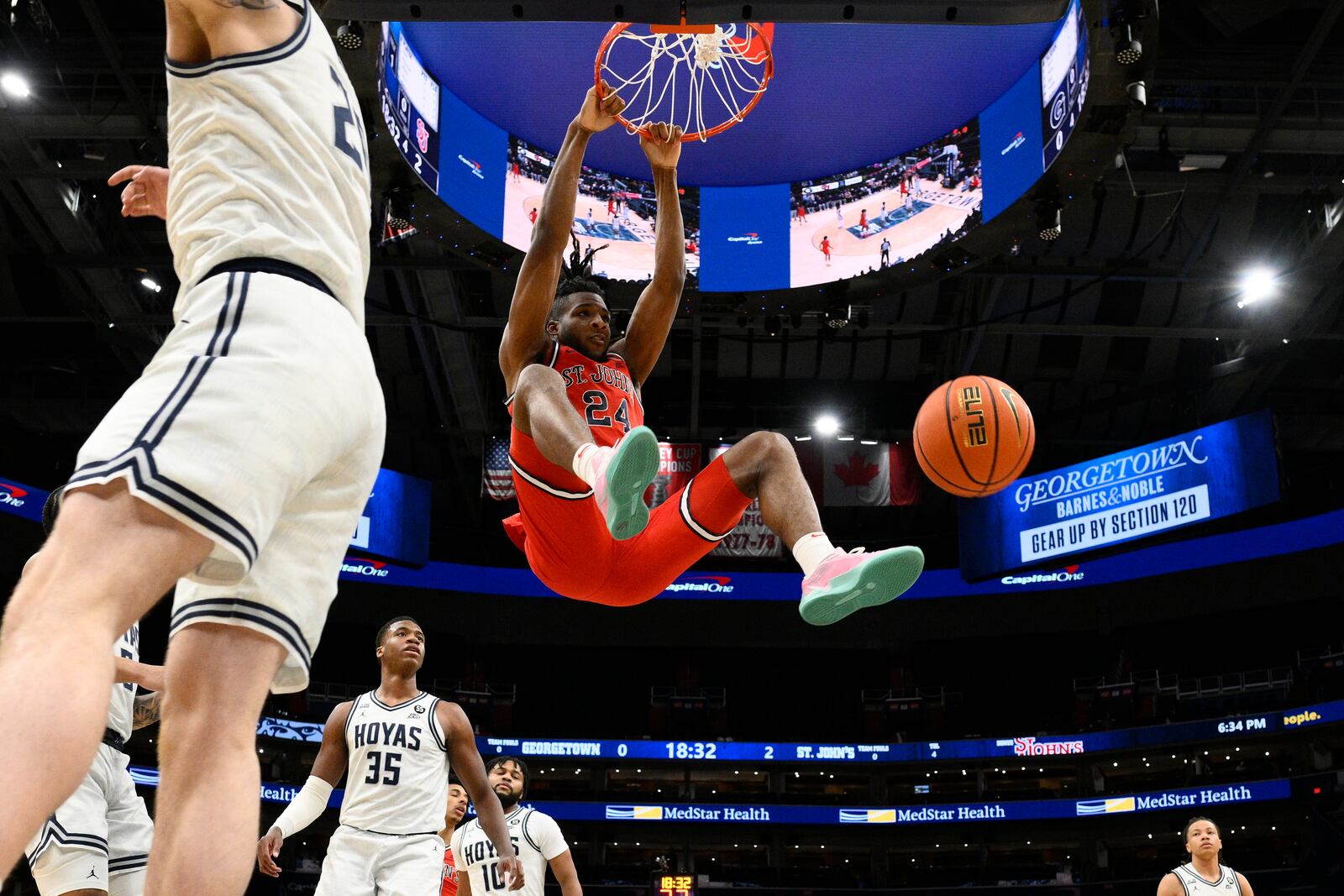 St. John's forward Zuby Ejiofor (24) dunks past Georgetown forward Thomas Sorber (35) during the first half of an NCAA college basketball game, Tuesday, Jan. 28, 2025, in Washington. (AP Photo/Nick Wass)