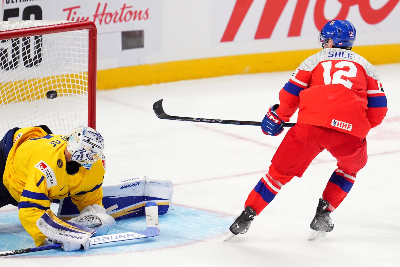 Czechia forward Eduard Sale (12) scores the game-winning goal against Sweden goaltender Marcus Gidlof (1) to win the World Junior hockey championship bronze medal penalty shot shootout, in Ottawa, Sunday, Jan. 5, 2025. (Sean Kilpatrick/The Canadian Press via AP)