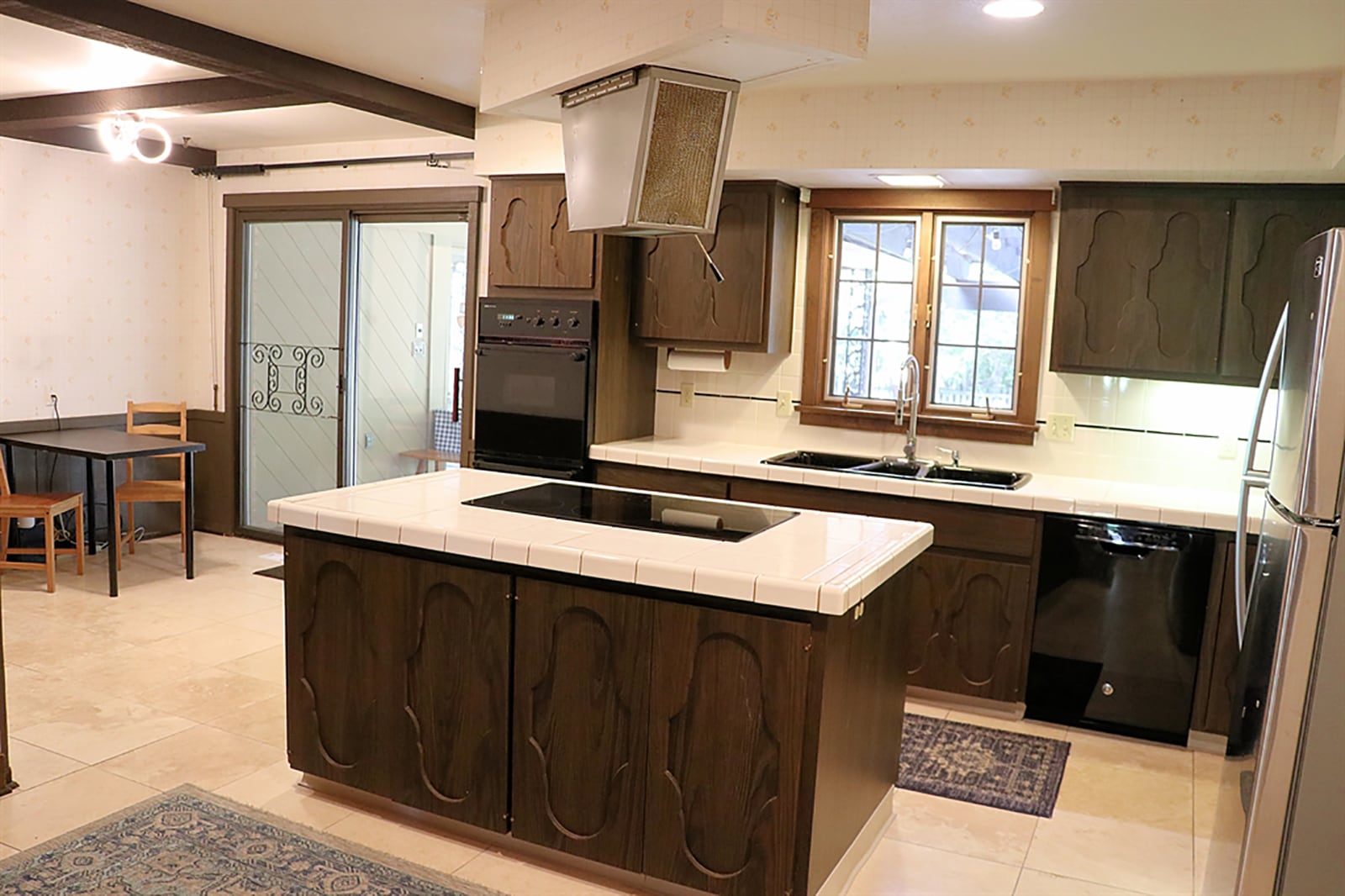 Accessible from both the family room and the dining room, the kitchen has an abundance of storage and work space. White ceramic-tile countertops complement the ornate arched-door cabinetry. CONTRIBUTED PHOTO BY KATHY TYLER