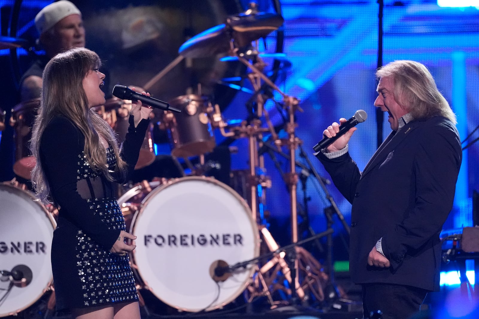 Chad Smith, from left, on drums, Kelly Clarkson, and Lou Gramm of Foreigner perform during the 39th Annual Rock & Roll Hall of Fame Induction Ceremony on Saturday, Oct. 19, 2024, at Rocket Mortgage FieldHouse in Cleveland. (AP Photo/Chris Pizzello)