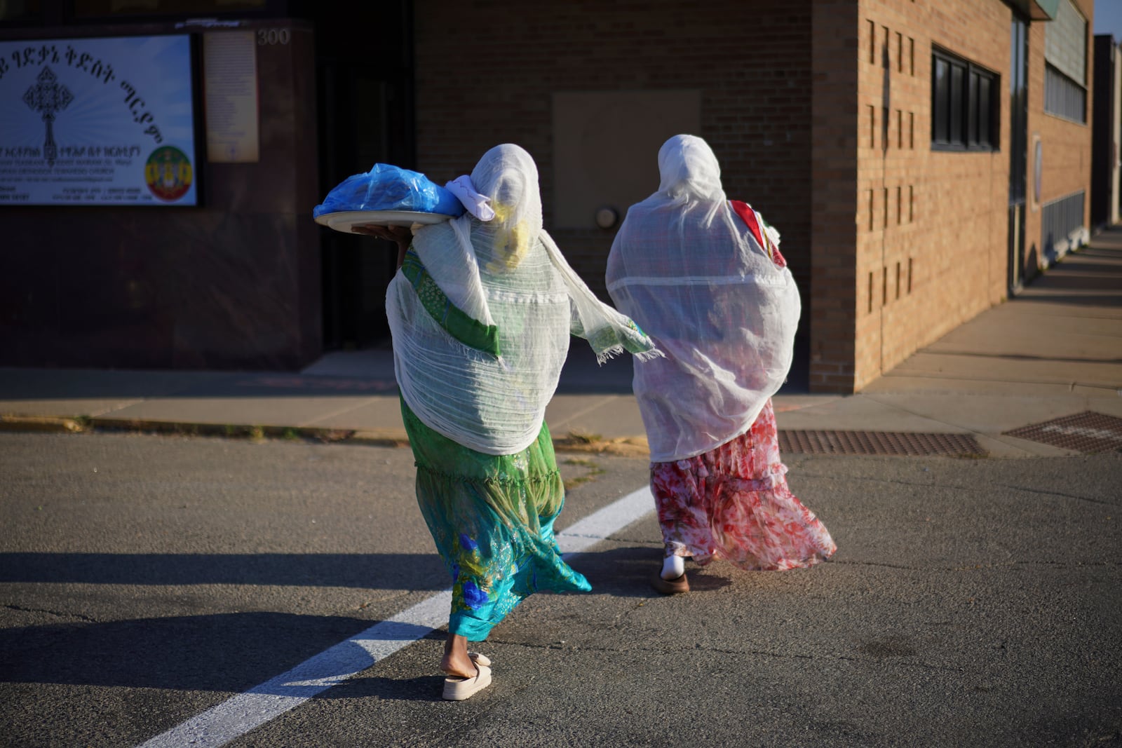 Members of the Ethiopian Orthodox Tewahedo Church carry food across the street on Sunday, Oct. 20, 2024, in Worthington, Minn. (AP Photo/Jessie Wardarski)