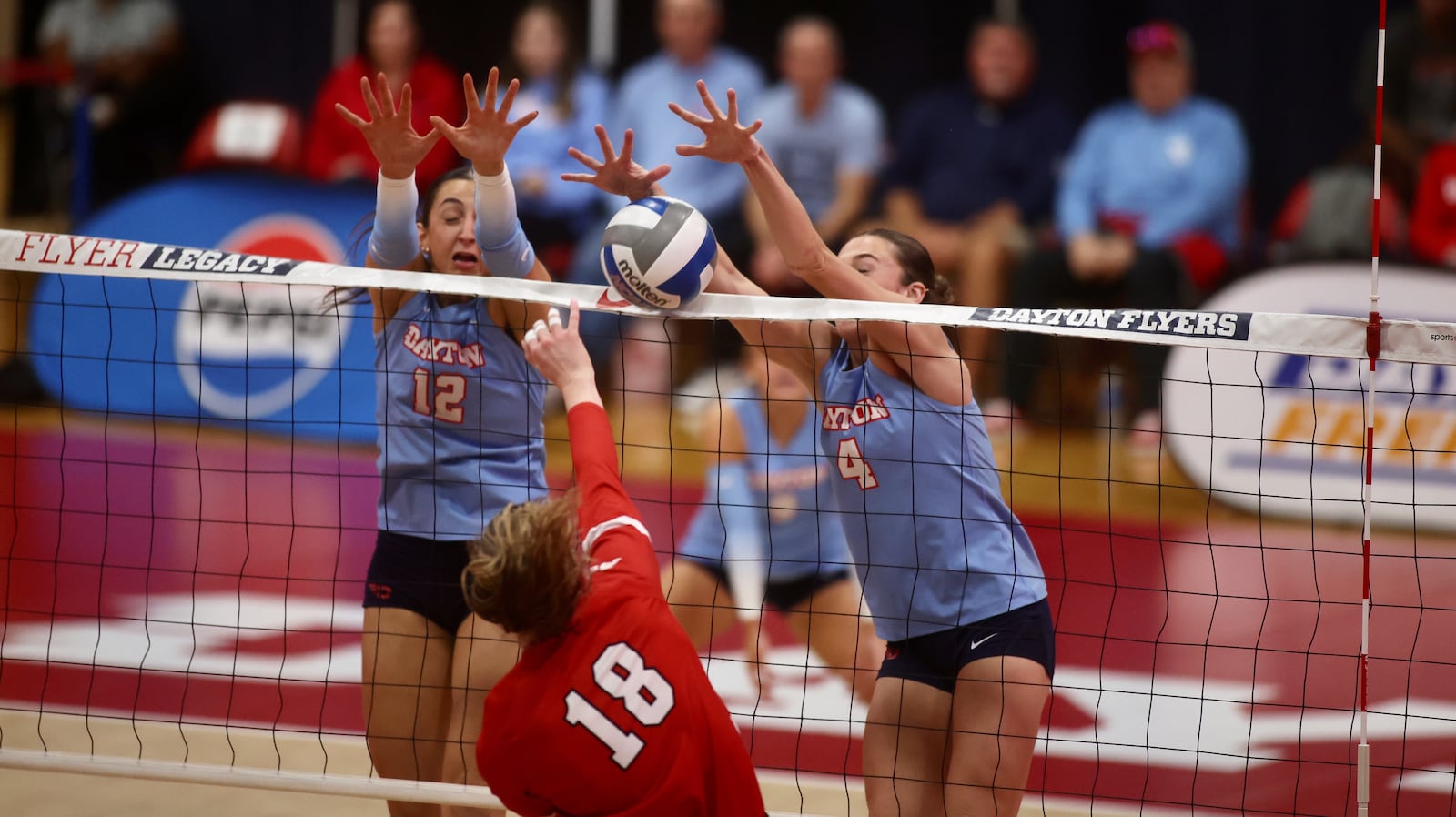 Dayton's Liana Sarkissian, left, and Lexie Almodovar, right, go up for a block against Davidson on Friday, Nov. 8, 2024, at the Frericks Center in Dayton. David Jablonski/Staff