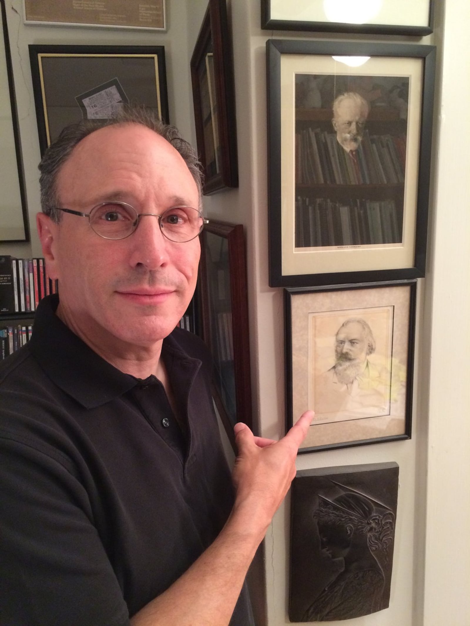 The Dayton Philharmonic Orchestra’s conductor, Neal Gittleman, points to a portrait of his favorite composer, Johannes Brahms. Submitted photo