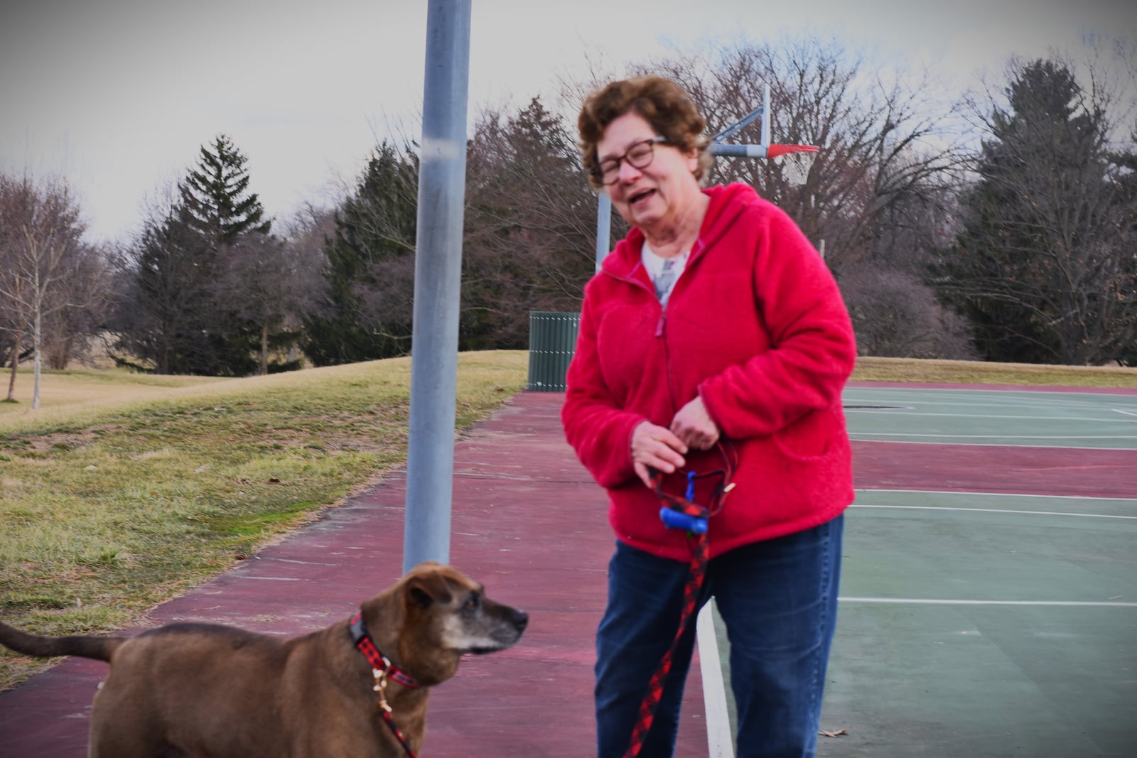 Lonnie Vilkas, 74, walks her dog, Amina, about twice a day at Belmont Park in southeast Dayton. CORNELIUS FROLIK / STAFF