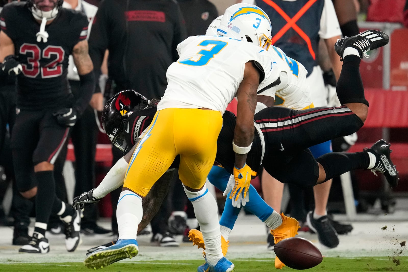 Arizona Cardinals running back James Conner fumbles the ball as he is hit by Los Angeles Chargers safety Derwin James Jr. (3) during the first half of an NFL football game, Monday, Oct. 21, 2024, in Glendale Ariz. The Cardinals recovered the fumble. (AP Photo/Matt York)