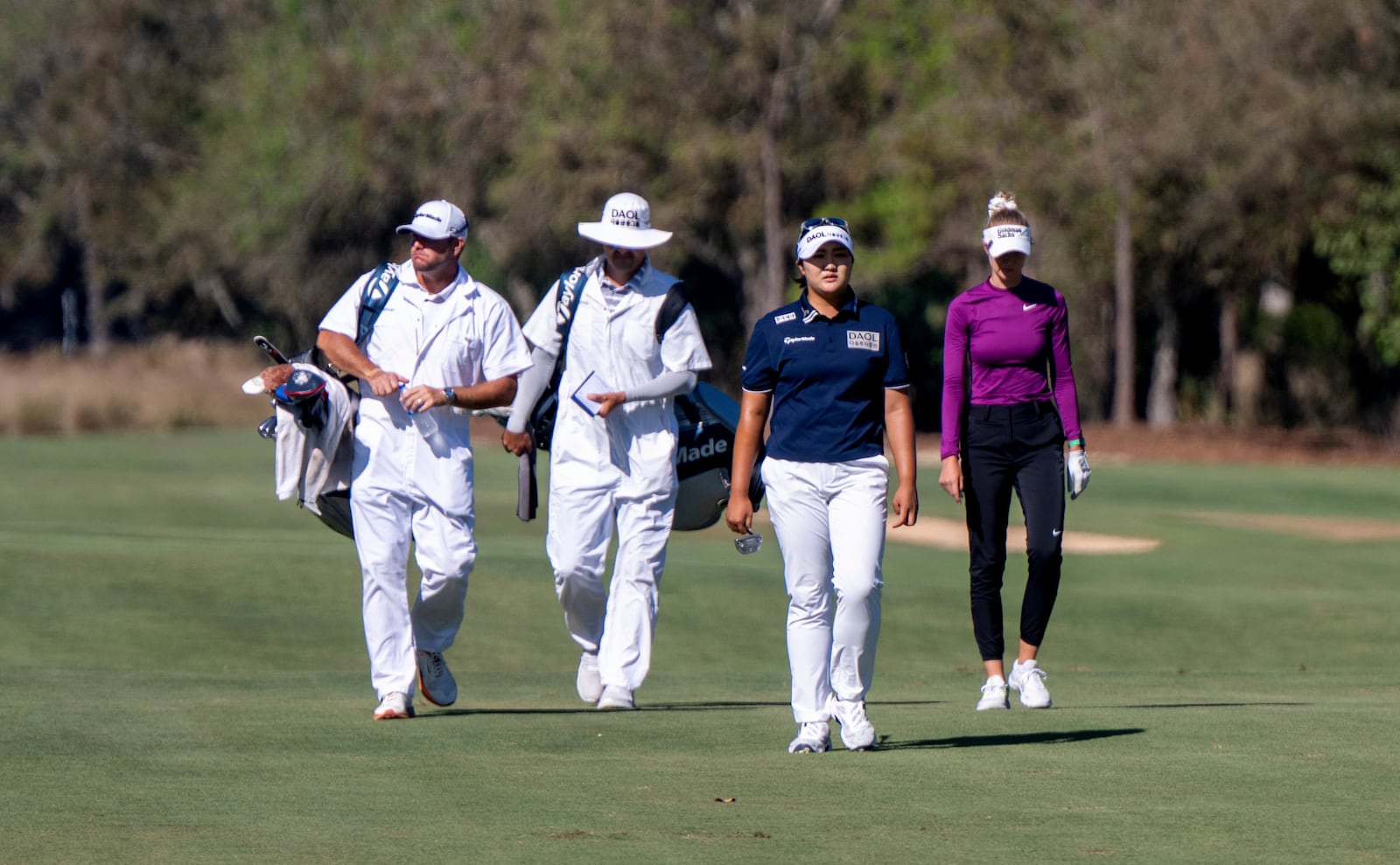 Hadrian Ryu, second from right, and Nelly Korda walk the fairway on the sixth hole during the first round of the LPGA CME Group Tour Championship golf tournament Thursday, Nov. 21, 2024, in Naples, Fla. (AP Photo/Chris Tilley)