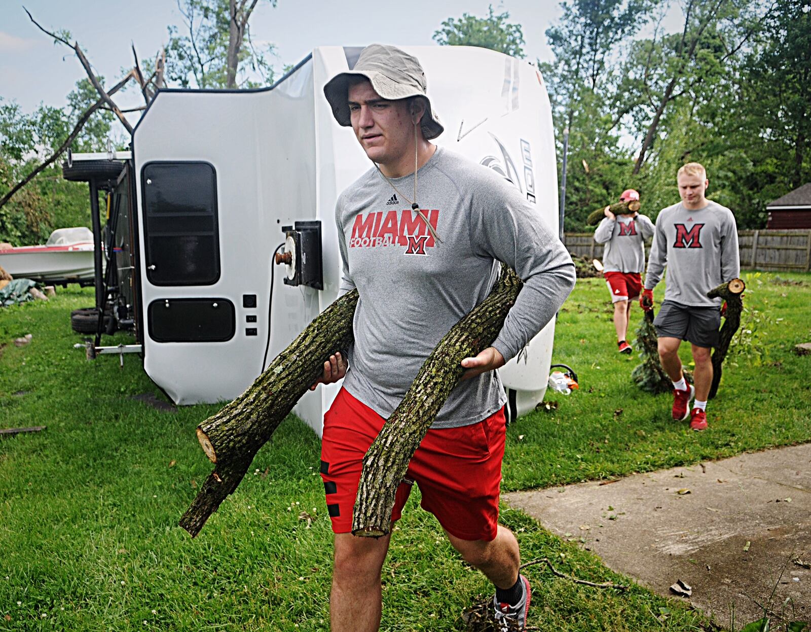 Miami football helps with cleanup of Beavercreek on Friday