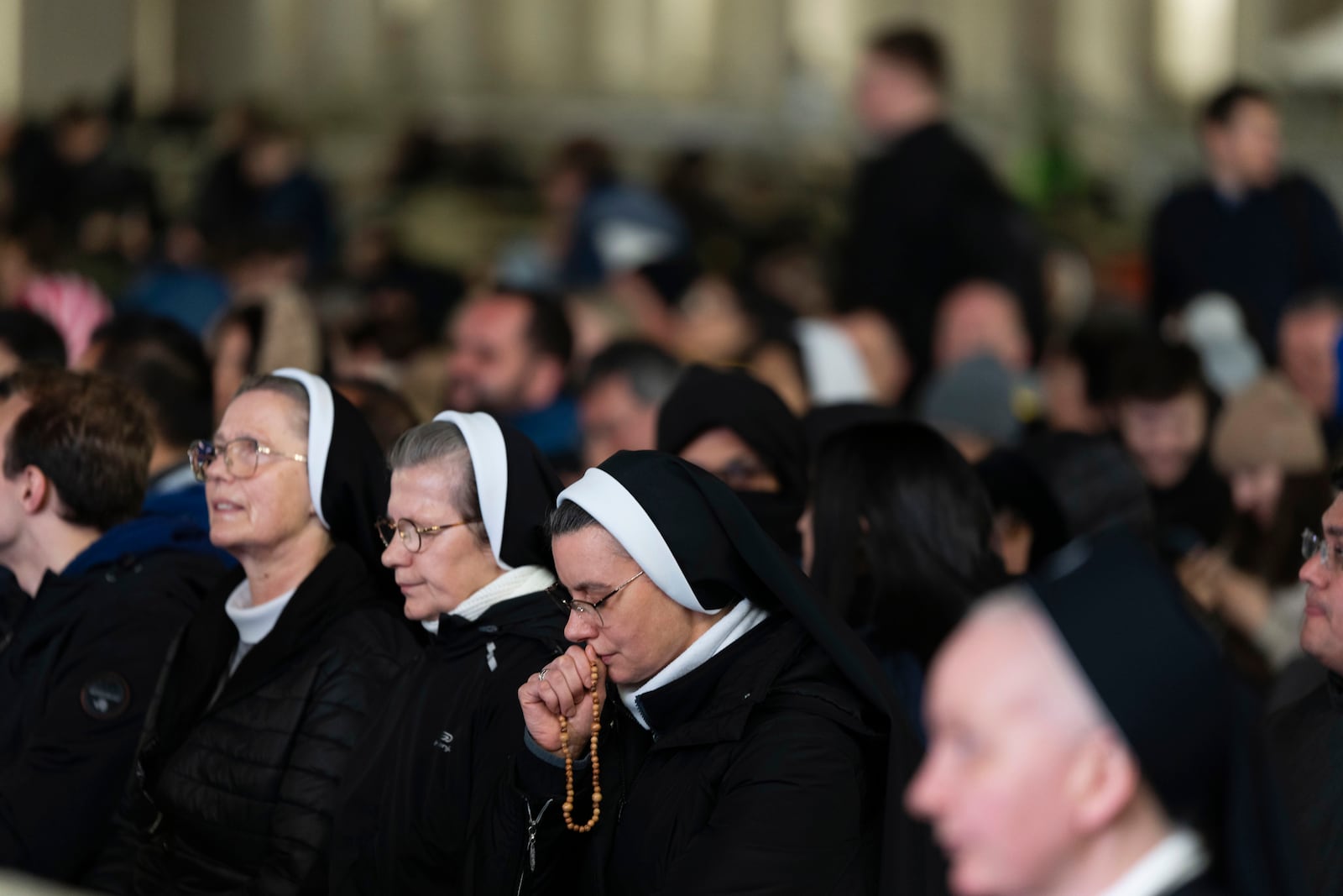 Catholic faithful attend a nightly rosary prayer for the health of Pope Francis in St. Peter's Square at the Vatican, Sunday, March 2, 2025. (AP Photo/Mosa'ab Elshamy)