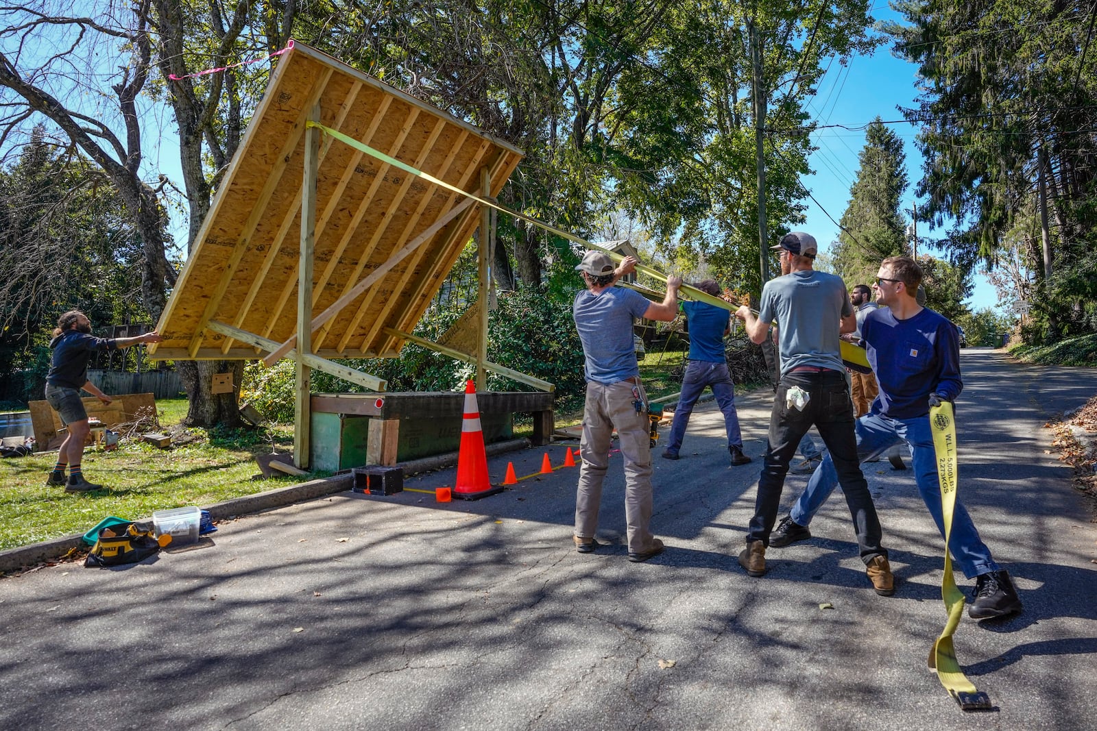 Volunteers work to lower the roof of a platform that will be used to provide water from a community well located on an urban farm that belongs to Bountiful Cities, a nonprofit organization, Monday, Oct. 14, 2024, in Asheville, N.C. (AP Photo/Kathy Kmonicek)