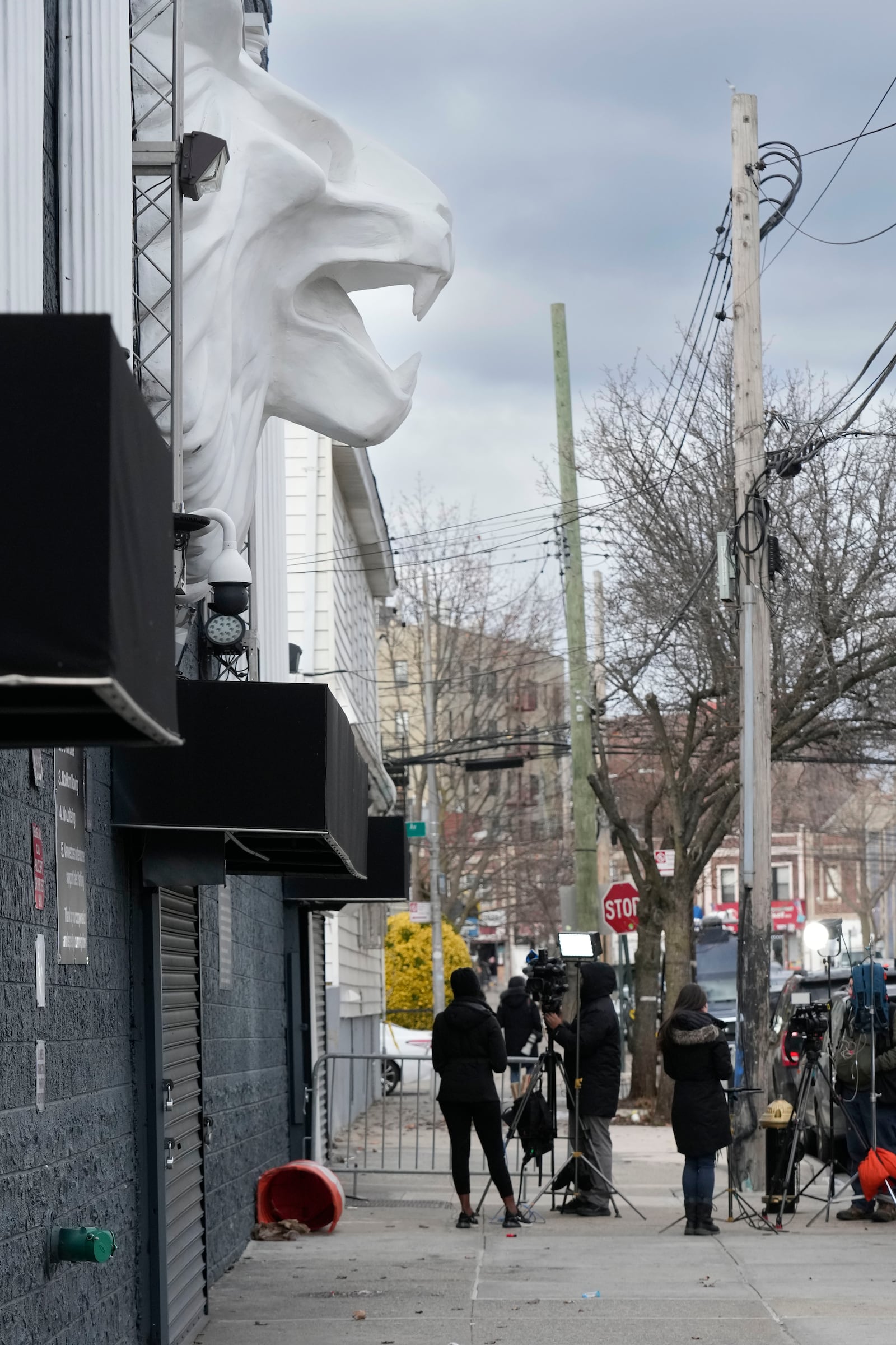 Members of the media work in front of the nightclub Amazura, left, in the Queens borough of New York, Thursday, Jan. 2, 2025. (AP Photo/Seth Wenig)