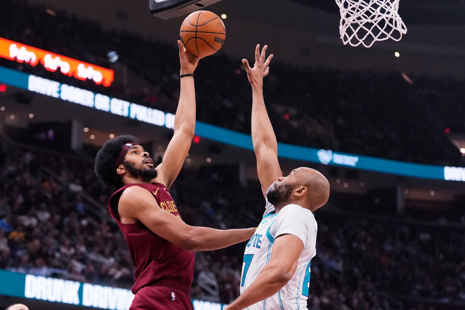 Cleveland Cavaliers center Jarrett Allen, left, shoots over Charlotte Hornets forward Taj Gibson in the first half of an NBA basketball game, Sunday, Jan. 5, 2025, in Cleveland. (AP Photo/Sue Ogrocki)