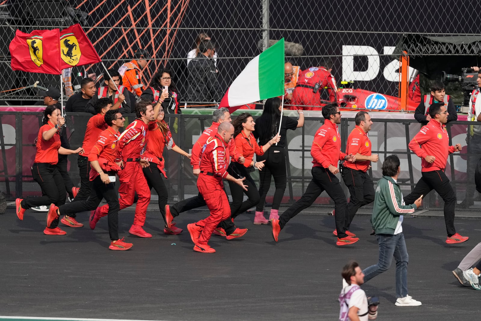 Ferrari teams members celebrate after Carlos Sainz of Spain winning the Formula One Mexico Grand Prix auto race at the Hermanos Rodriguez racetrack in Mexico City, Sunday, Oct. 27, 2024. (AP Photo/Eduardo Verdugo)