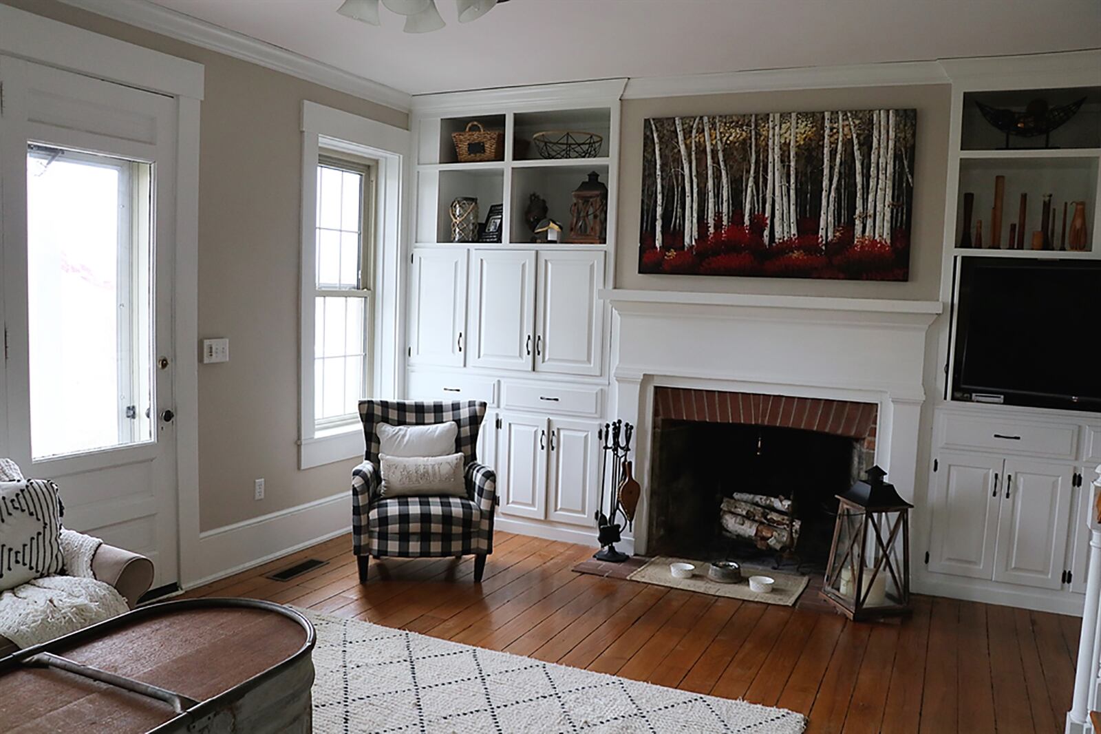 The family room has the open wooden staircase that leads to the upper level. A wall has built-ins that surround a decorative fireplace with brick surround. The built-ins include cabinets, drawers, open bookcases and a media cabinet. CONTRIBUTED PHOTO BY KATHY TYLER