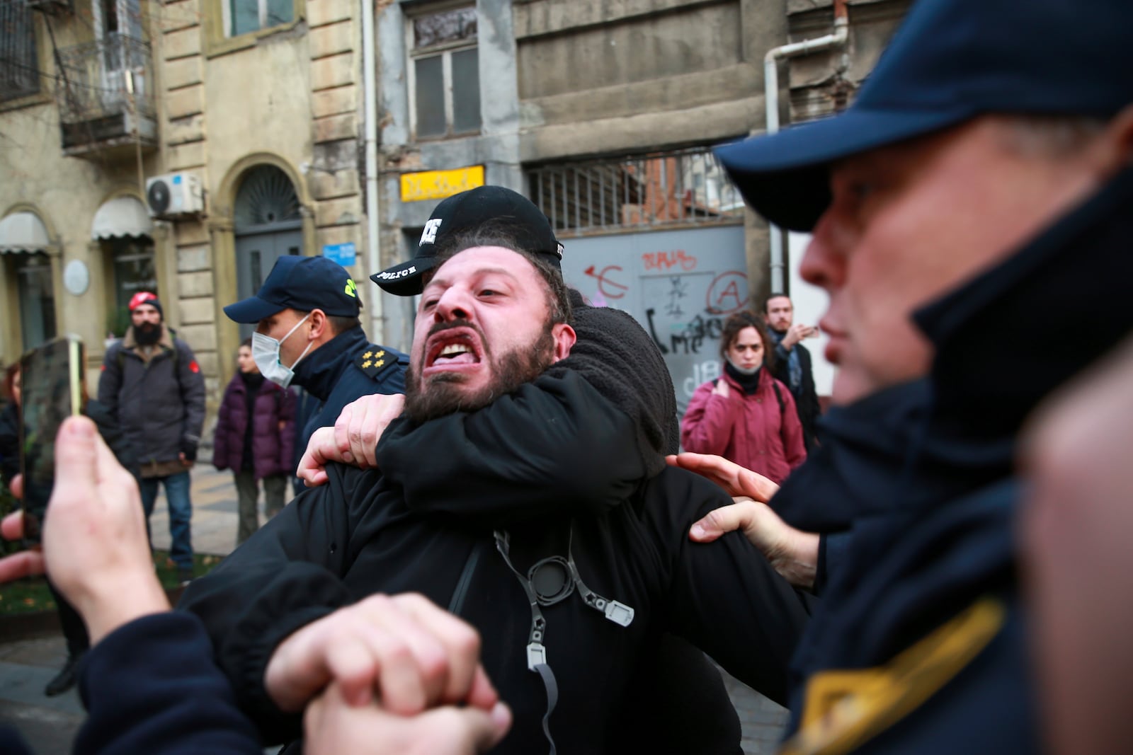 Police try to detain a protester on a street during a rally against the results of the parliamentary elections amid allegations that the vote was rigged in Tbilisi, Georgia, on Tuesday, Nov. 19, 2024. (AP Photo/Zurab Tsertsvadze)