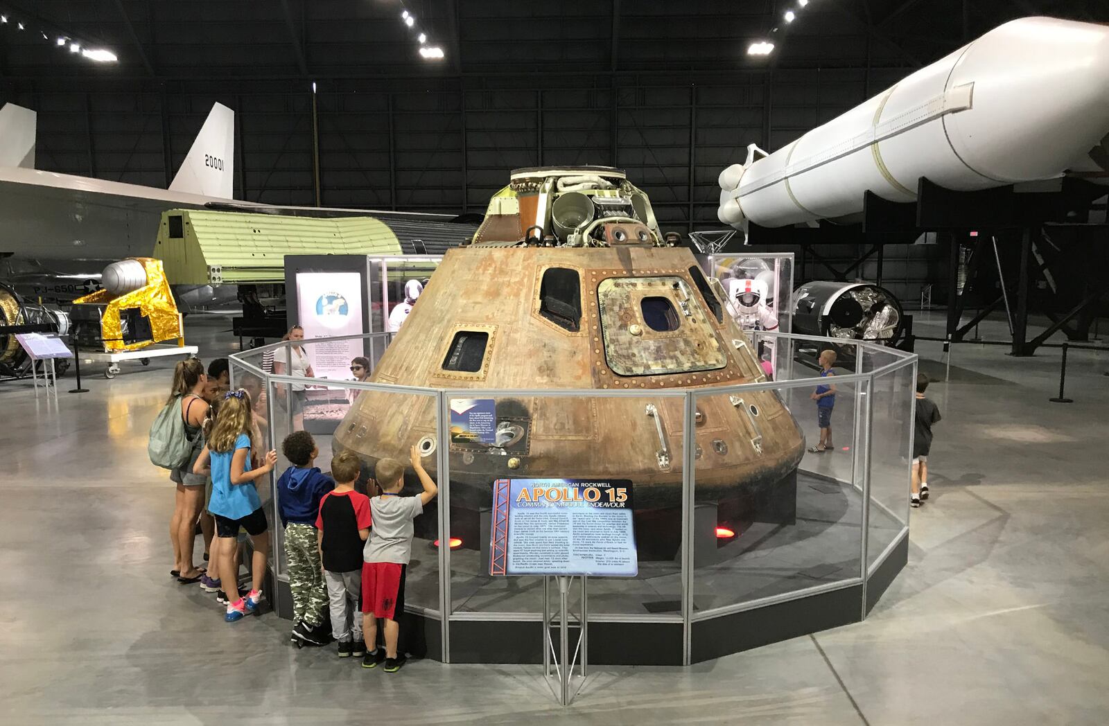 Students from the Yellow Springs Community Learning Center gathered around the Apollo 15 command module in the National Museum of the U.S. Air Force in July, shortly before the 50th Anniversary of the Apollo 11 lunar landing July 20. CHUCK HAMLIN / STAFF