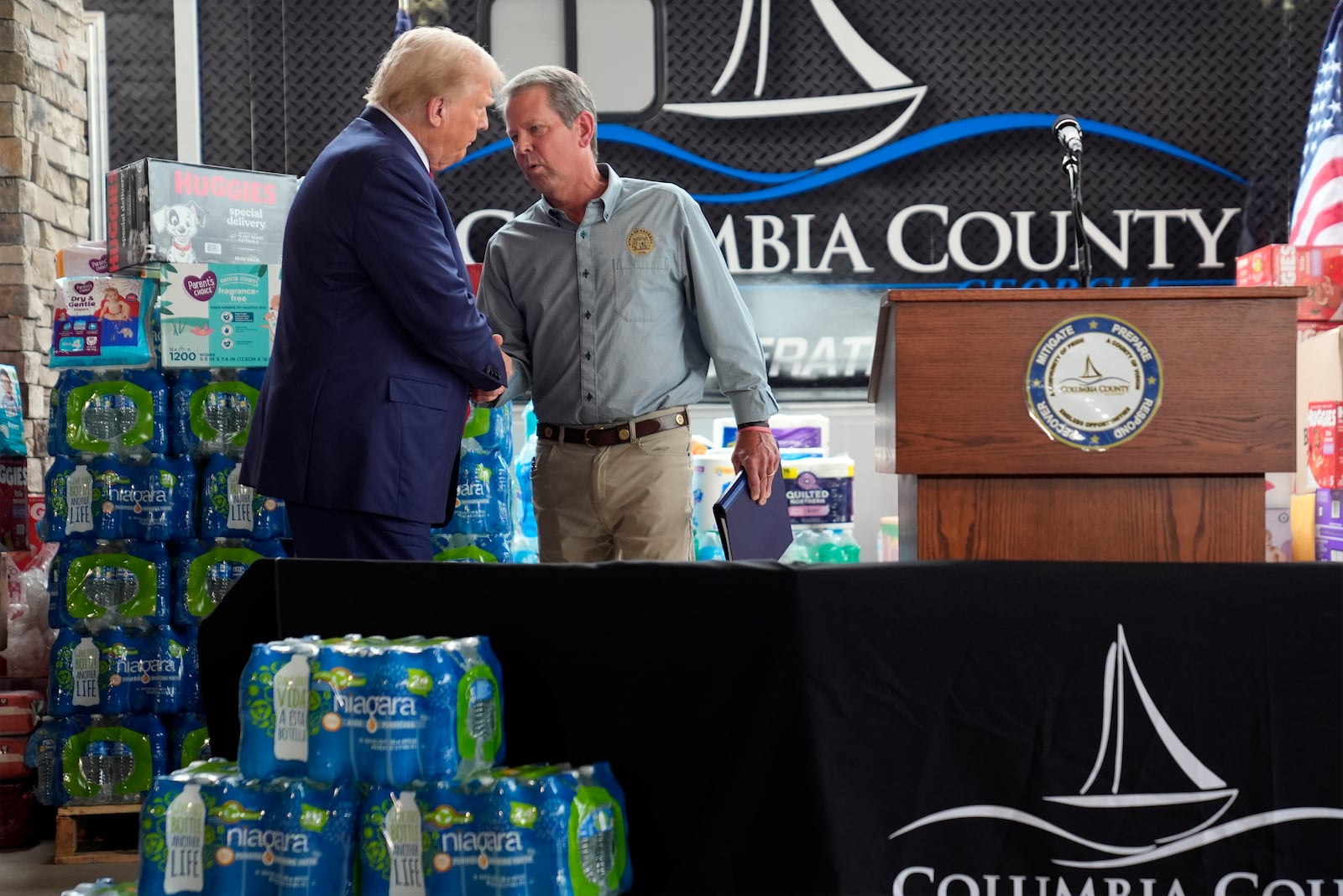 Republican presidential nominee former President Donald Trump shakes hands with Georgia Gov. Brian Kemp at a temporary relief shelter as he visits areas impacted by Hurricane Helene, Friday, Oct. 4, 2024, in Evans, Ga. (AP Photo/Evan Vucci)