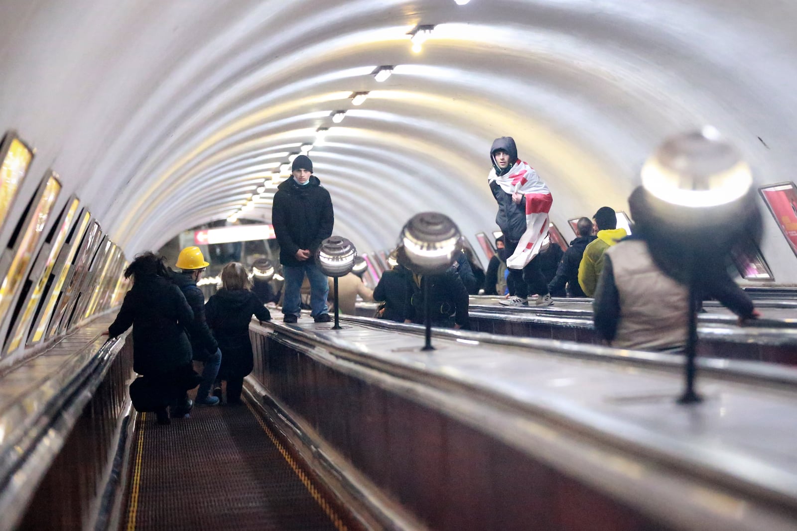 Demonstrators go down an escalator to hide from the police in a subway station during a rally against the government's decision to suspend negotiations on joining the European Union for four years in Tbilisi, Georgia, Monday, Dec. 2, 2024. (AP Photo/Zurab Tsertsvadze)