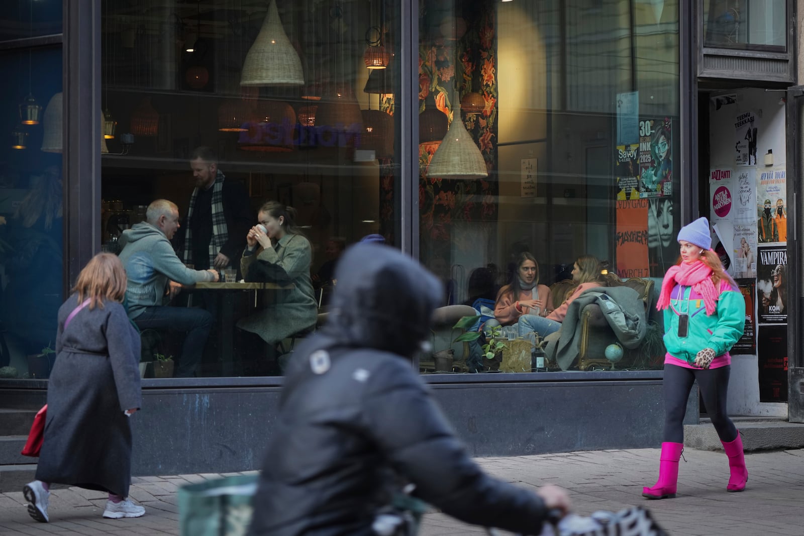 People walk along a shopping street in the center of Helsinki, Finland, Saturday, March 15, 2025. (AP Photo/Sergei Grits)