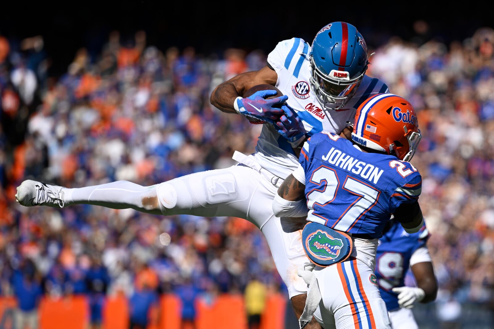 Mississippi wide receiver Tre Harris (9) is hit by Florida defensive back Dijon Johnson (27), forcing an incomplete pass during the first half of an NCAA college football game, Saturday, Nov. 23, 2024, in Gainesville, Fla. (AP Photo/Phelan M. Ebenhack)