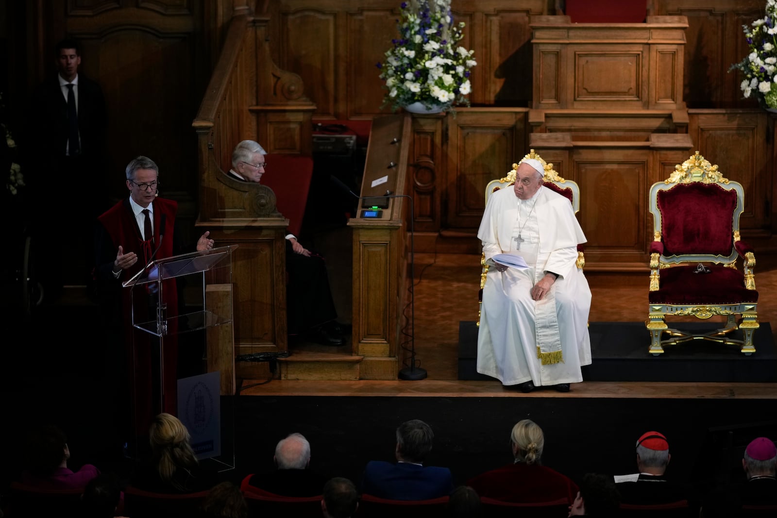 Pope Francis, right, listens to Rector Luc Sels's speech during his meeting with the professors in the Promotiezaal of the Catholic University of Leuven, Belgium, Friday, Sept. 27, 2024. (AP Photo/Andrew Medichini)