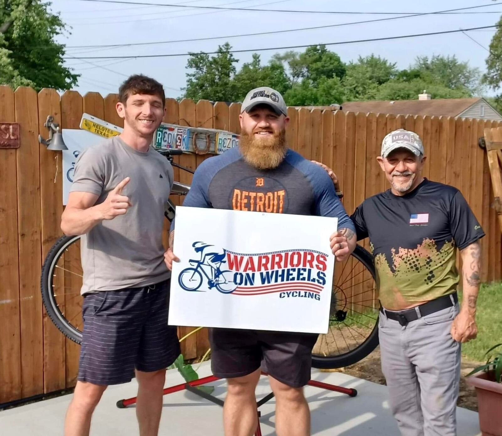 Zach Haney (left) and Gil Esparza (right) of Warriors on Wheels present a bike to U.S. Marine Corps veteran Jeremy Wertz. CONTRIBUTED