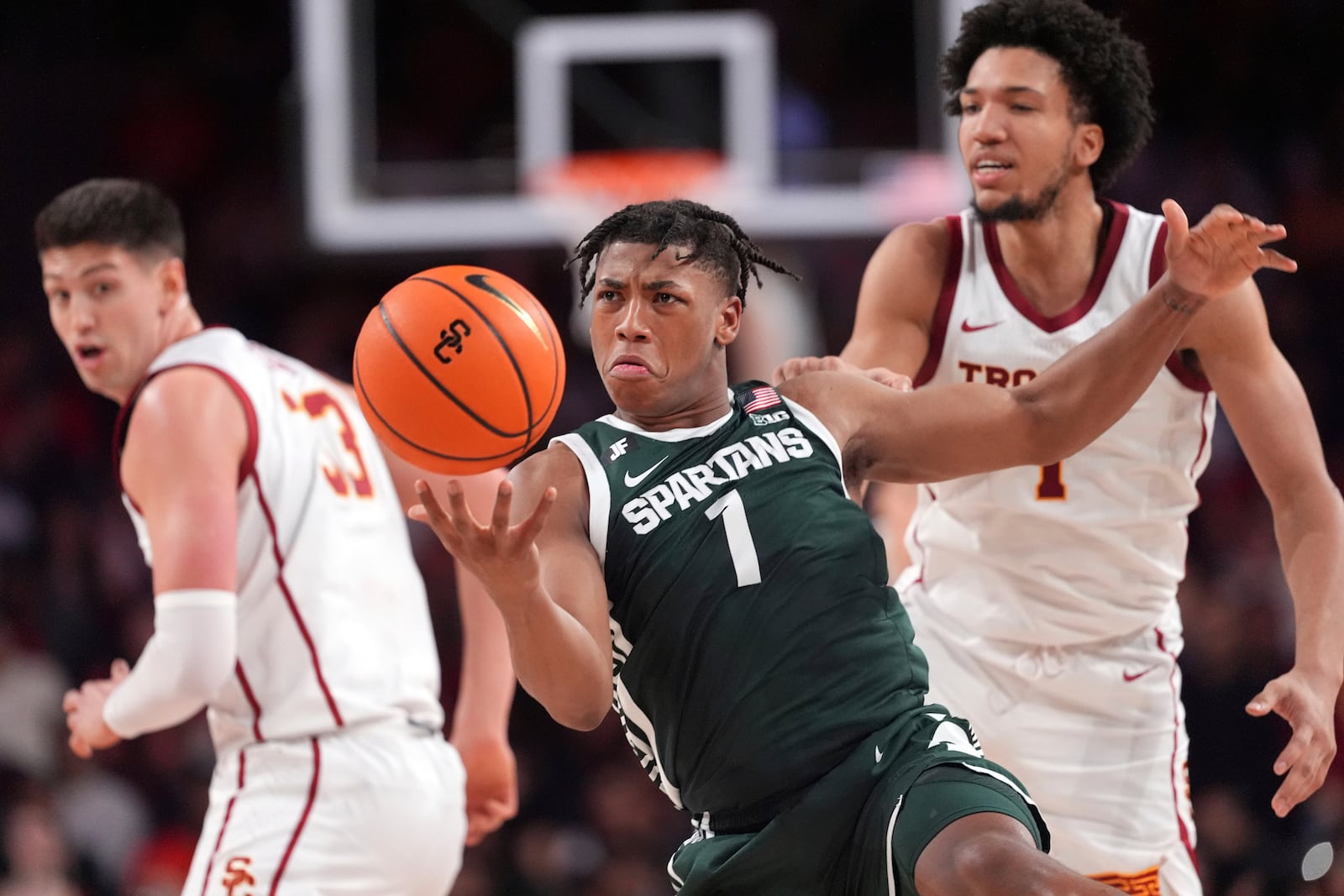 Michigan State guard Jeremy Fears Jr., center, steals the ball from Southern California guard Desmond Claude, right, as forward Josh Cohen watches during the first half of an NCAA college basketball game, Saturday, Feb. 1, 2025, in Los Angeles. (AP Photo/Mark J. Terrill)