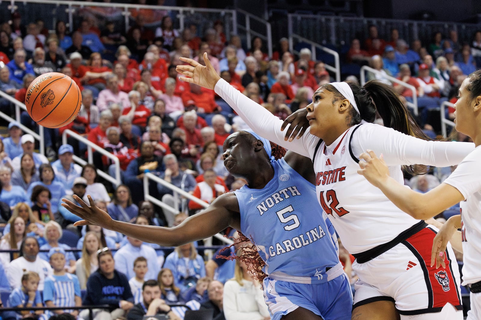 North Carolina State's Mallory Collier (42) and North Carolina's Maria Gakdeng (5) reach for a ball during the second half of an NCAA college basketball game in the semifinals of the Atlantic Coast Conference tournament in Greensboro, N.C., Saturday, March 8, 2025. (AP Photo/Ben McKeown